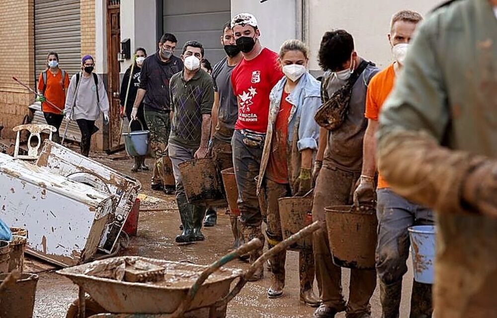 Un grupo de universitarios forma una cadena para cargar cubos. 